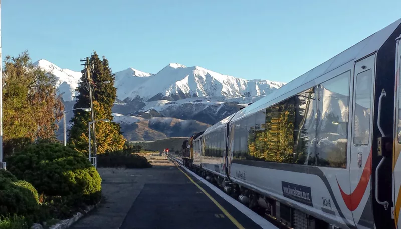 TranzAlpine train at Springfield Station with Southern Alps behind