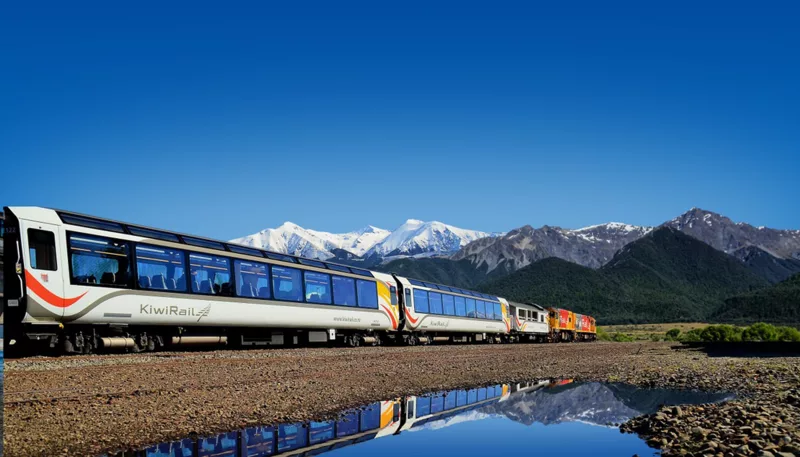 TranzAlpine train with Southern Alps reflected in water