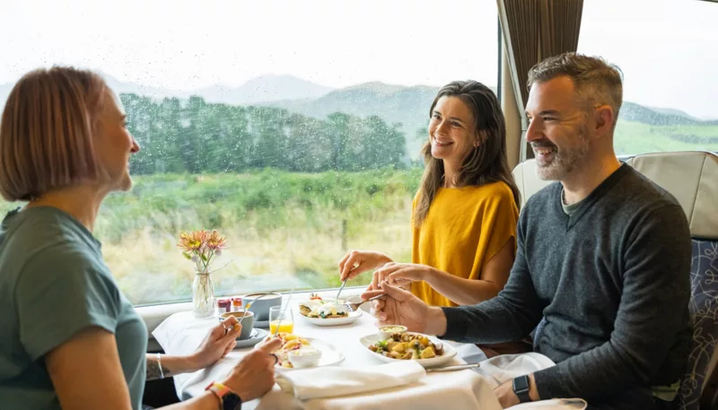Friends dining in Scenic Plus carriage aboard the TranzAlpine