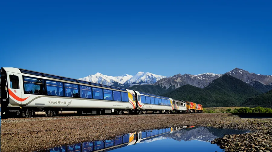 TranzAlpine train with Southern Alps reflected in water