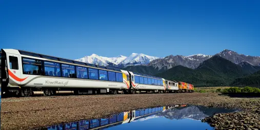TranzAlpine train with Southern Alps reflected in water