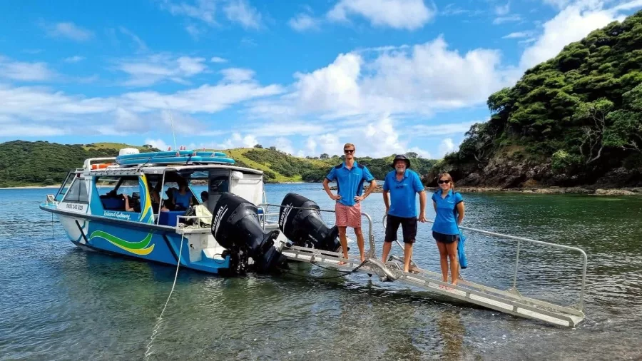 Cruise crew greeting guests at a beach landing in the Bay of Islands