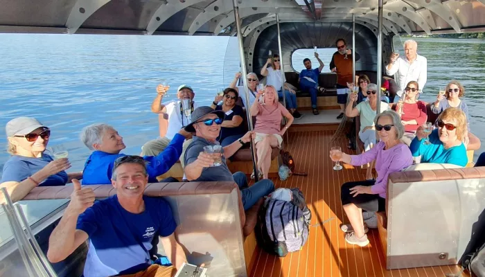 Group raising glasses aboard a boat on Lake Rotoiti near Rotorua