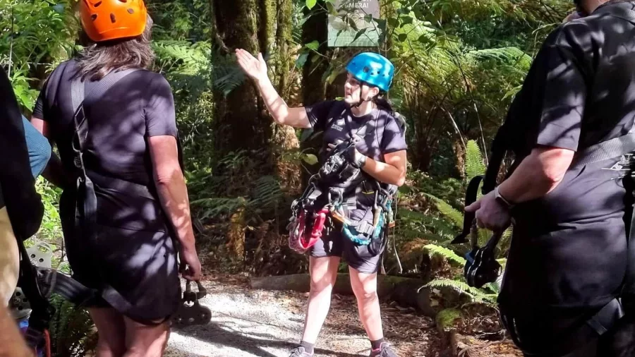 Eco-tour guide instructing visitors on a Rotorua forest ziplining experience