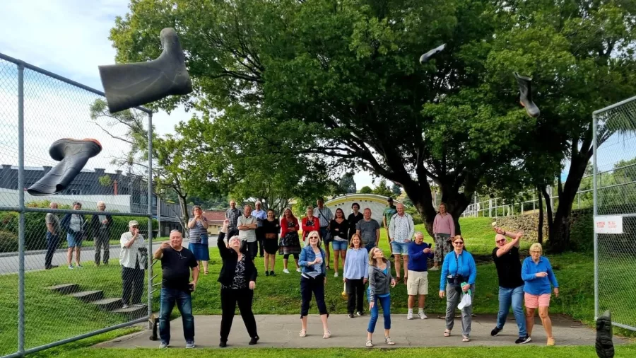 Group of people competing in a gumboot throwing event in Taihape, New Zealand