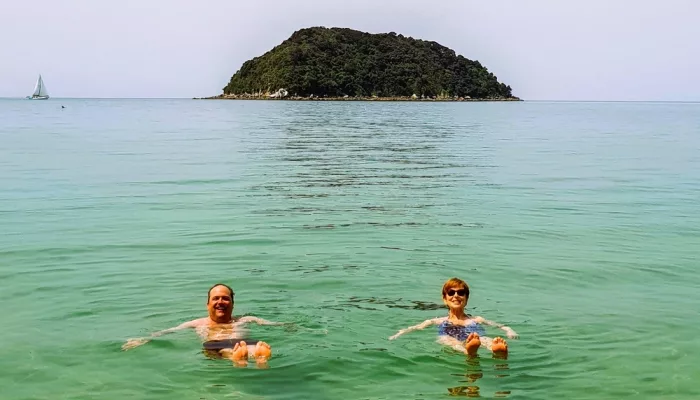 Guests swimming in crystal-clear waters of Abel Tasman