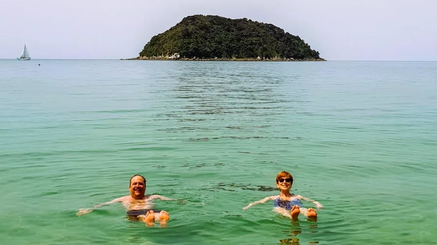 Guests swimming in crystal-clear waters of Abel Tasman