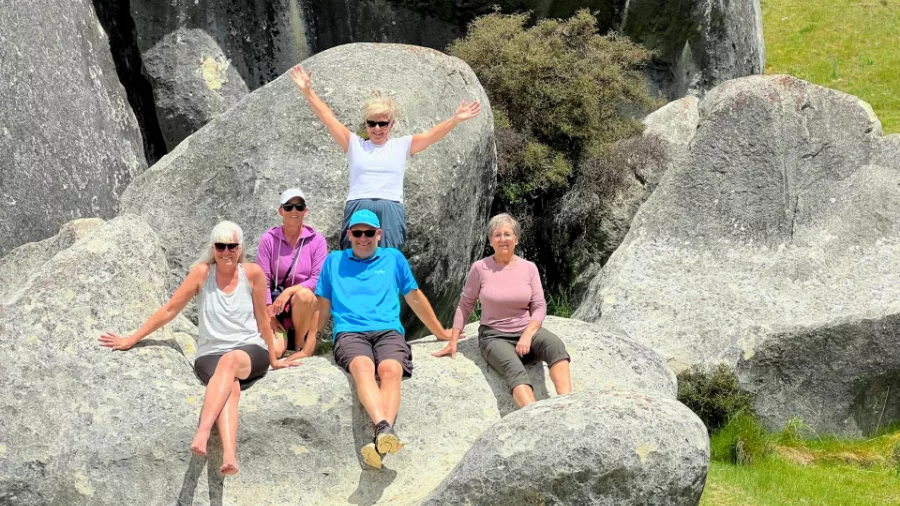 Group of guests relaxing on boulders at Castle Hill in Canterbury