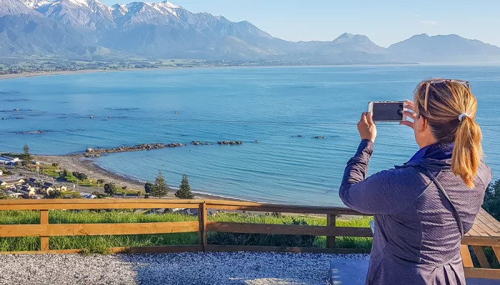 Traveller photographing Kaikōura coastline from lookout