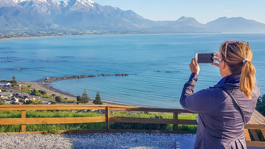 Traveller photographing Kaikōura coastline from lookout