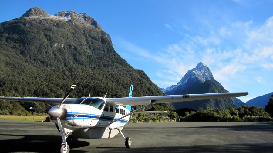 Scenic flight aircraft on tarmac with Mitre Peak backdrop