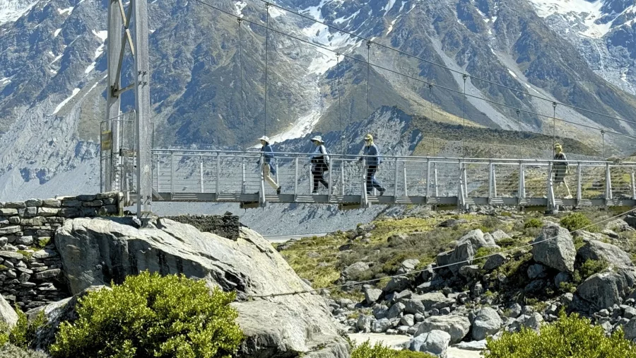 Guests crossing bridge on Hooker Valley Track
