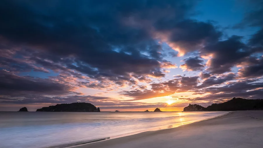 Island silhouette under dramatic sky at Coromandel coastline