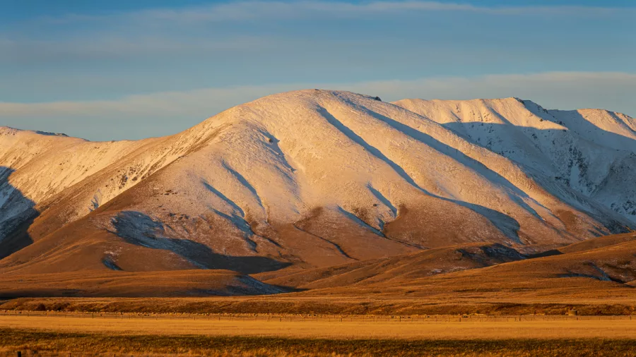 Snow-covered hill glowing at golden hour in the Mackenzie Country