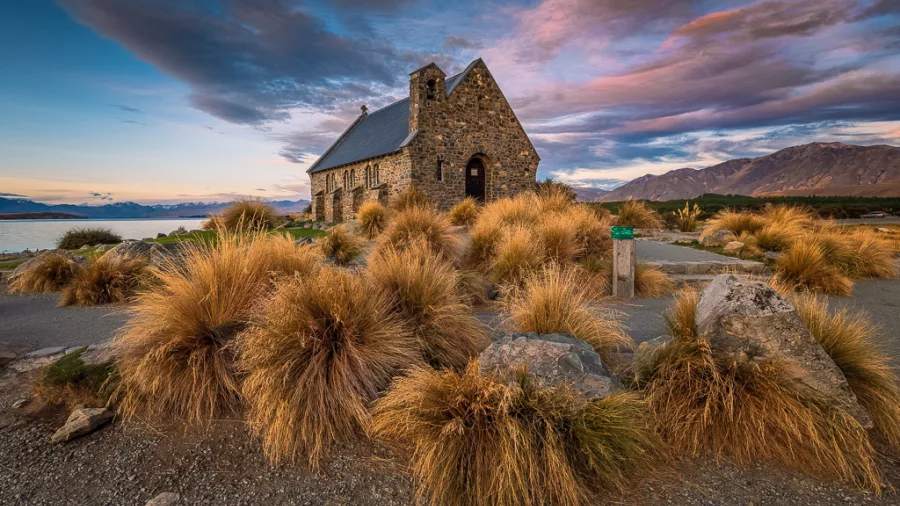 Church of the Good Shepherd at Lake Tekapo under a dramatic sunset sky