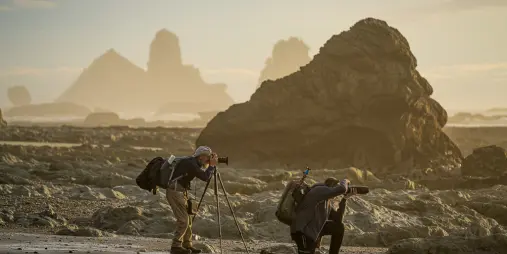 Photographers shooting sea stacks on West Coast beach