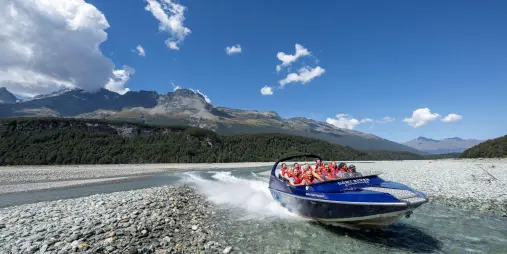 Jet boat making a fast turn in shallow waters of Dart River