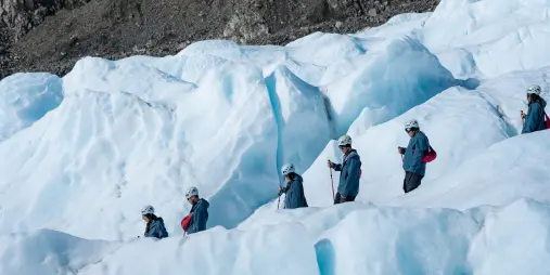 Tour group navigating wide open glacier field at Franz Josef