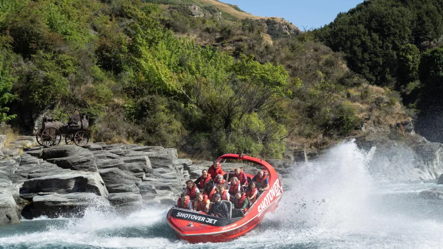 Shotover Jet with antique mining tractor on rocks