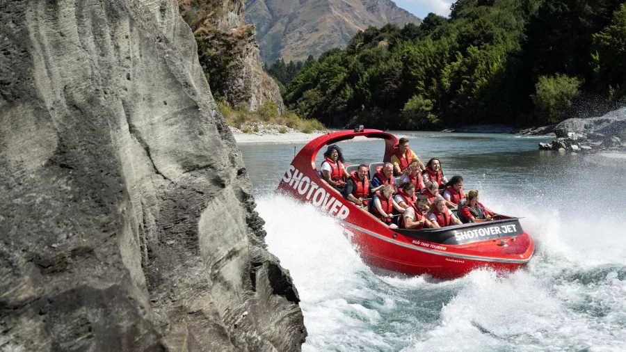 Shotover Jet boat close to rock wall on river