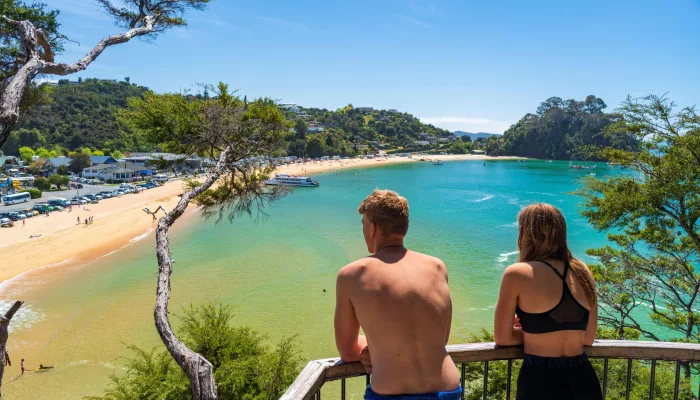 Two people enjoying the view from a lookout over Kaiteriteri Beach