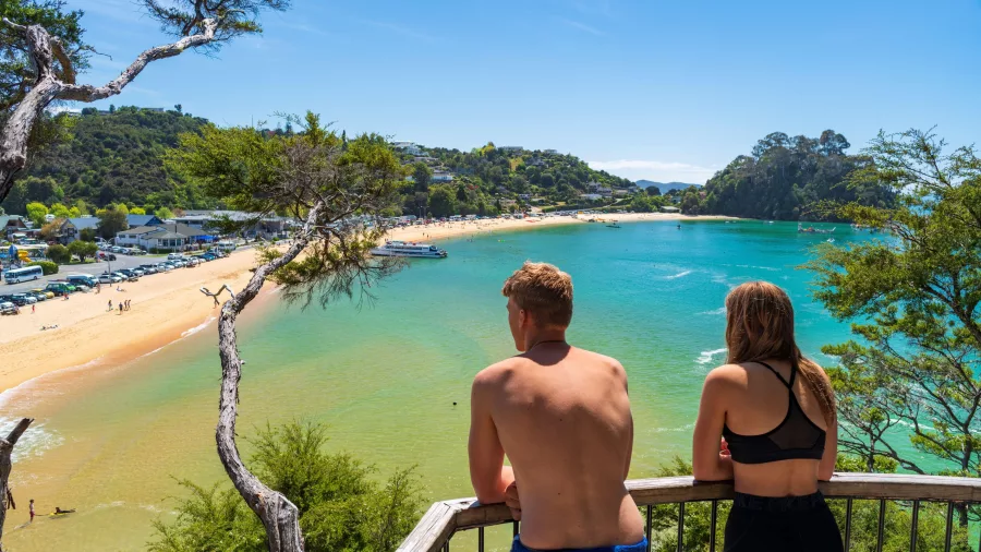Two people enjoying the view from a lookout over Kaiteriteri Beach