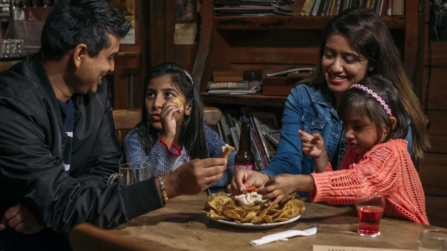 Family sharing food at the Mussel Inn in Takaka, Golden Bay
