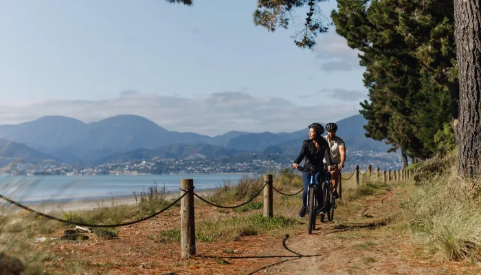 Cyclists on a coastal path at Rabbit Island along the Great Taste Trail to Mapua