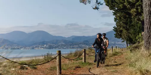 Cyclists on a coastal path at Rabbit Island along the Great Taste Trail to Mapua