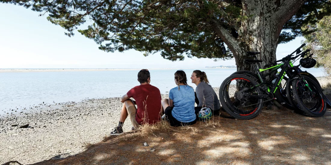 Cyclists taking a break in the shade beside the Great Taste Trail on the Ruby Coast