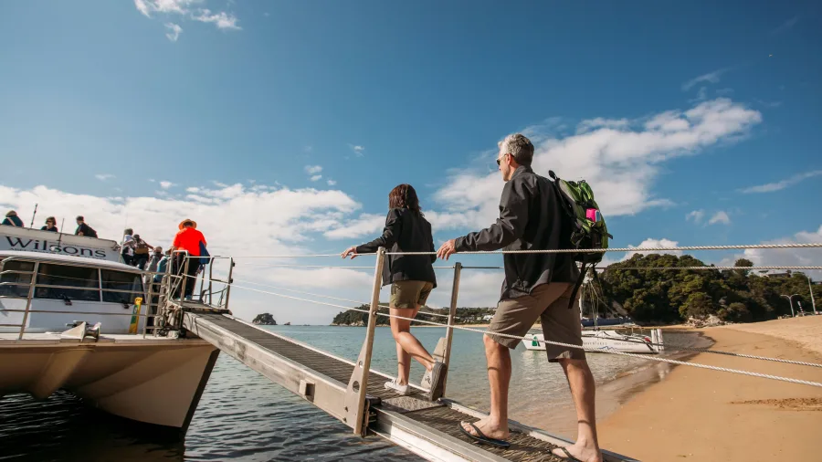 Visitors boarding Wilson’s Abel Tasman National Park cruise from Kaiteriteri Beach