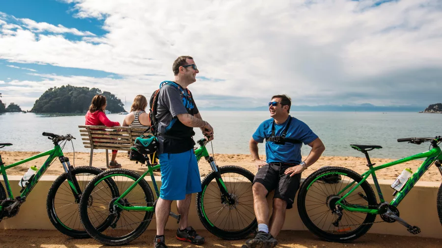 Cyclists relaxing at Kaiteriteri Beach, Nelson Tasman