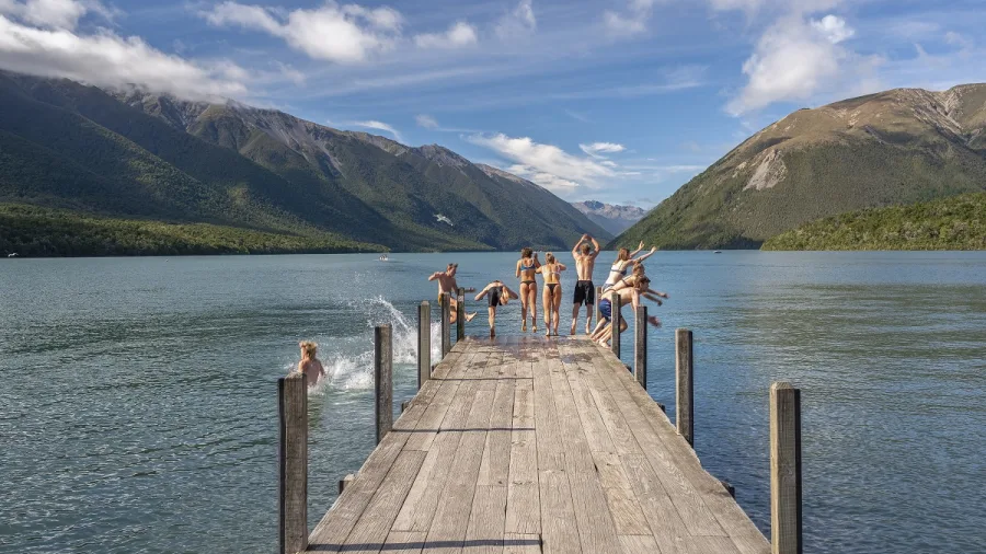 Group jumping off jetty into Lake Rotoiti Nelson Lakes National Park