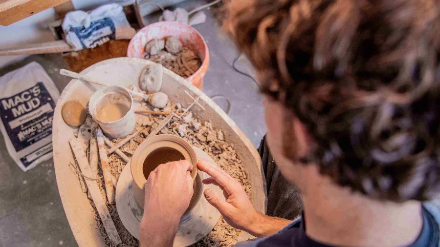 Potter shaping clay at Kiln Studio in Nelson New Zealand