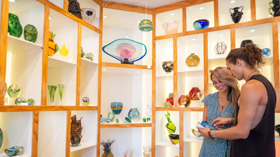 Couple browsing glass art at Flamedaisy Glass Blowing Studio in Nelson New Zealand