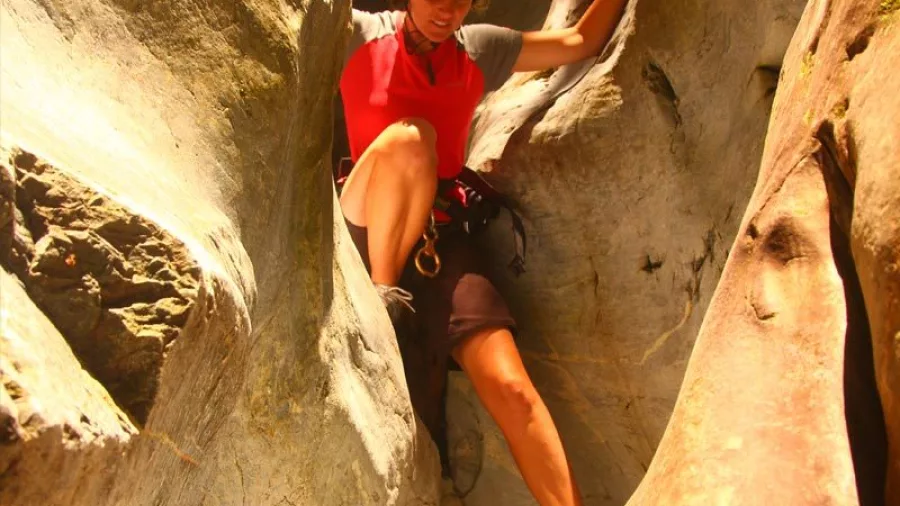 Canyoner carefully descending sandstone rock in Blue Creek, Kahurangi