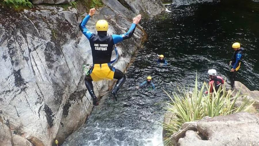 Canyoner leaping into a deep rock pool during Falls River canyoning trip