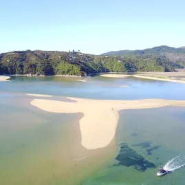 Aerial view of tidal sand formations and a boat near Marahau at the southern entrance to Abel Tasman National Park