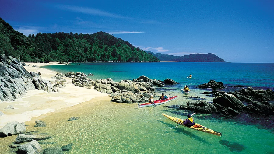 Kayakers exploring turquoise waters and sculpted granite coastline in Abel Tasman National Park
