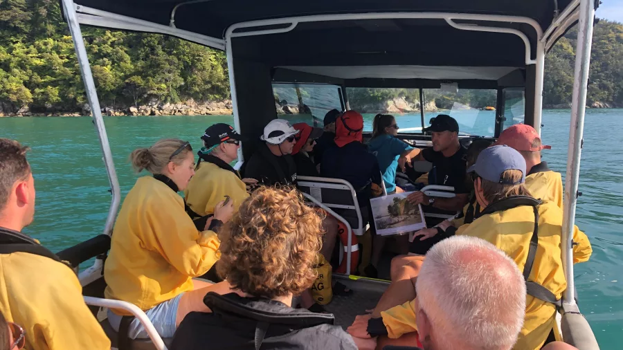 Travellers on an Abel Tasman Kayaks water taxi cruising through turquoise waters