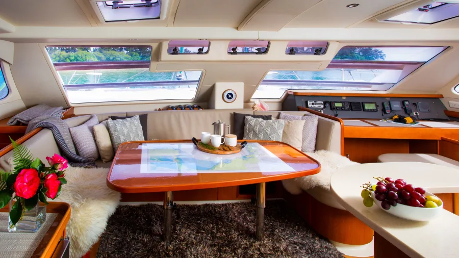 Saloon area inside catamaran with chart table and plush seating