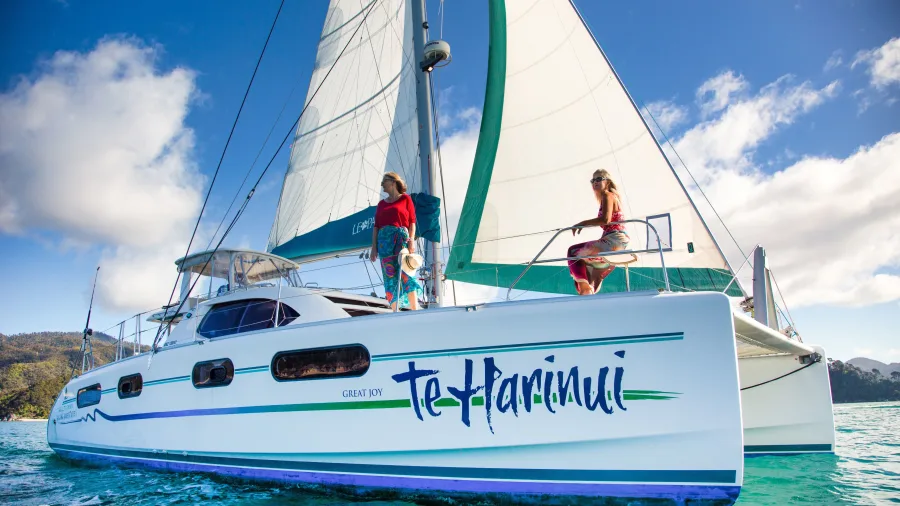 Te Harinui catamaran sailing in Abel Tasman with two women on deck