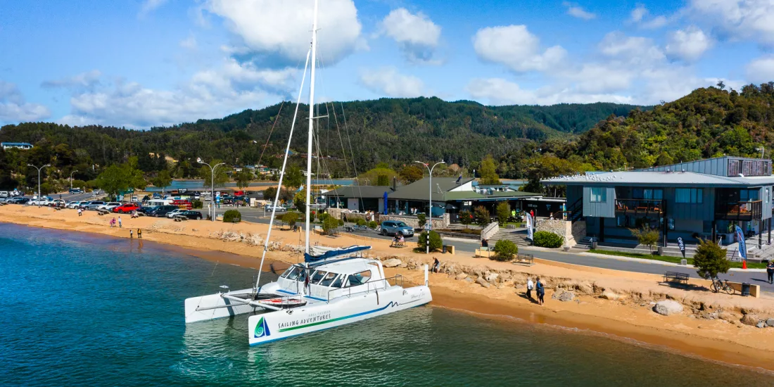 Catamaran docked at Kaiteriteri Beach ready for Abel Tasman sailing tour