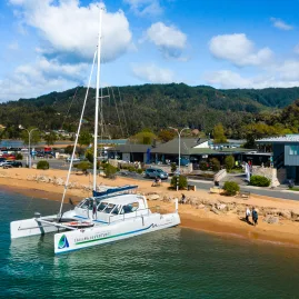 Catamaran docked at Kaiteriteri Beach ready for Abel Tasman sailing tour