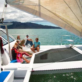 Family relaxing on deck during an Abel Tasman catamaran sailing tour