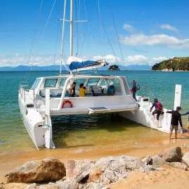 Catamaran anchored near the beach during a day sailing tour in Abel Tasman