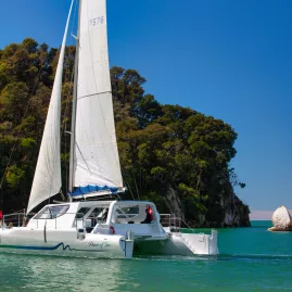 Catamaran sailing close to Split Apple Rock in Abel Tasman National Park