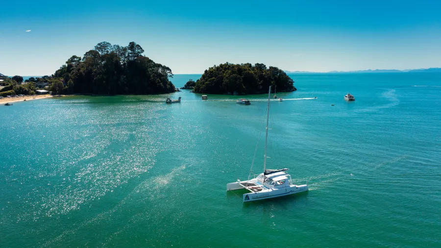 Catamaran moored near Kaiteriteri with coastal islands in the background
