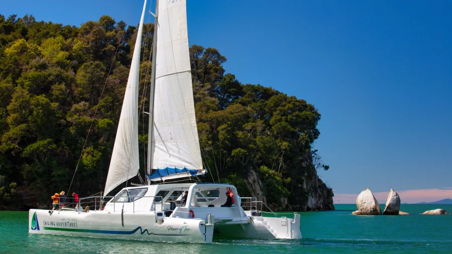 Catamaran sailing close to Split Apple Rock in Abel Tasman National Park