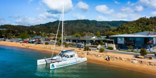 Catamaran docked at Kaiteriteri Beach ready for Abel Tasman sailing tour